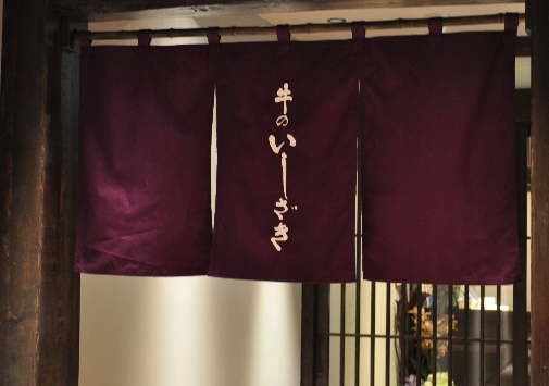 The entrance, marked by a purple noren curtain